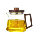 Glazen theepot met uitneembare infuser en walnoothouten handgreep op witte achtergrond