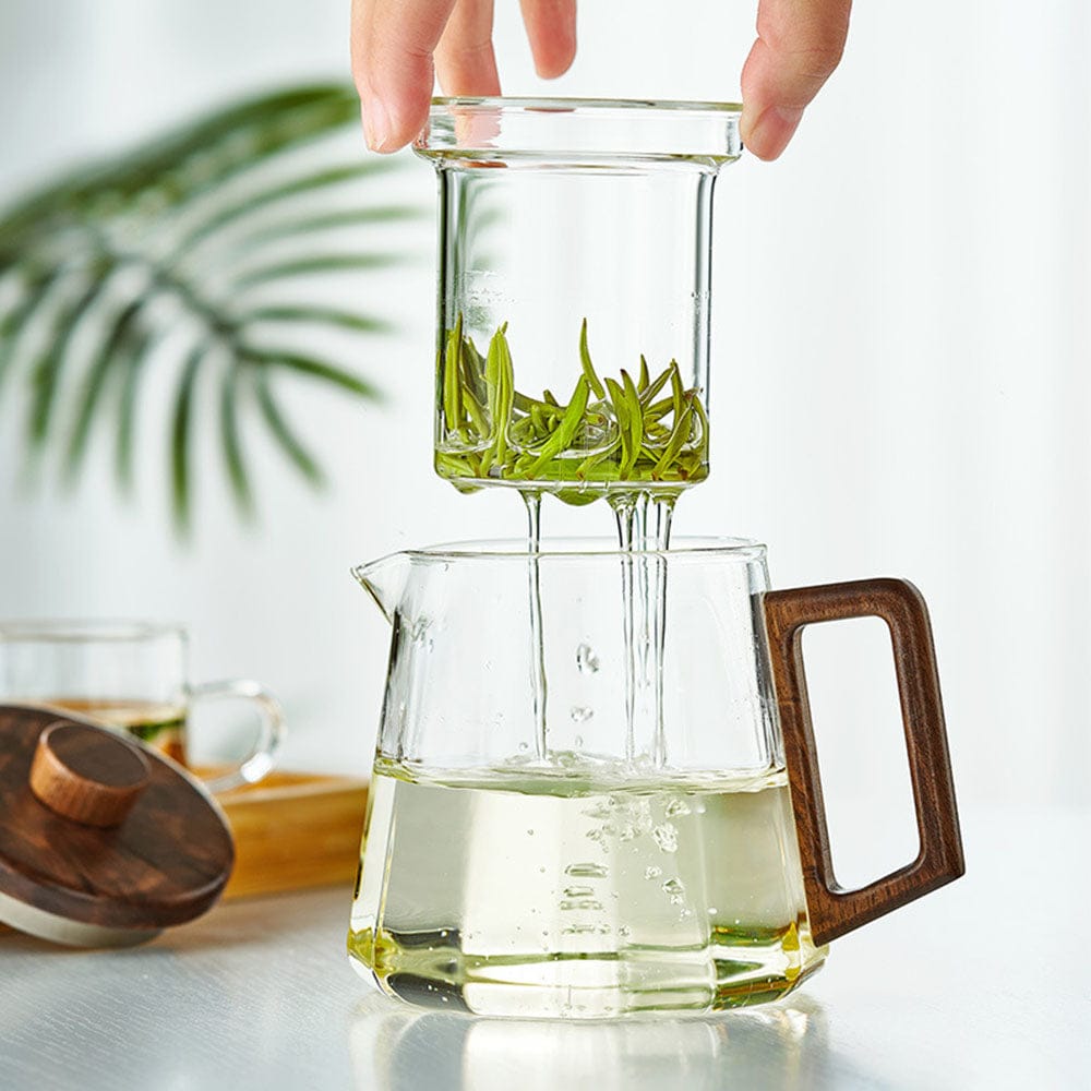 Uitneembare glazen infuser boven de theepot met walnoothouten handgreep