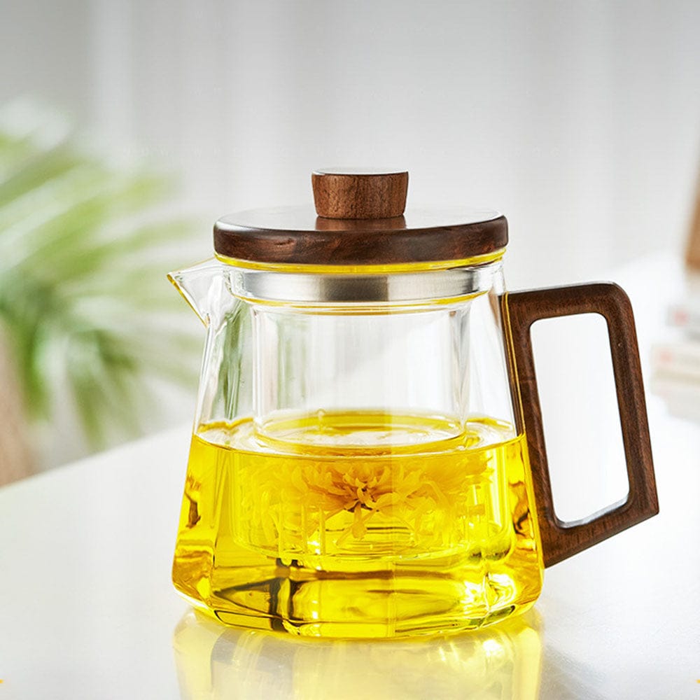 Glazen theepot met walnoothouten handgreep en deksel, gevuld met thee